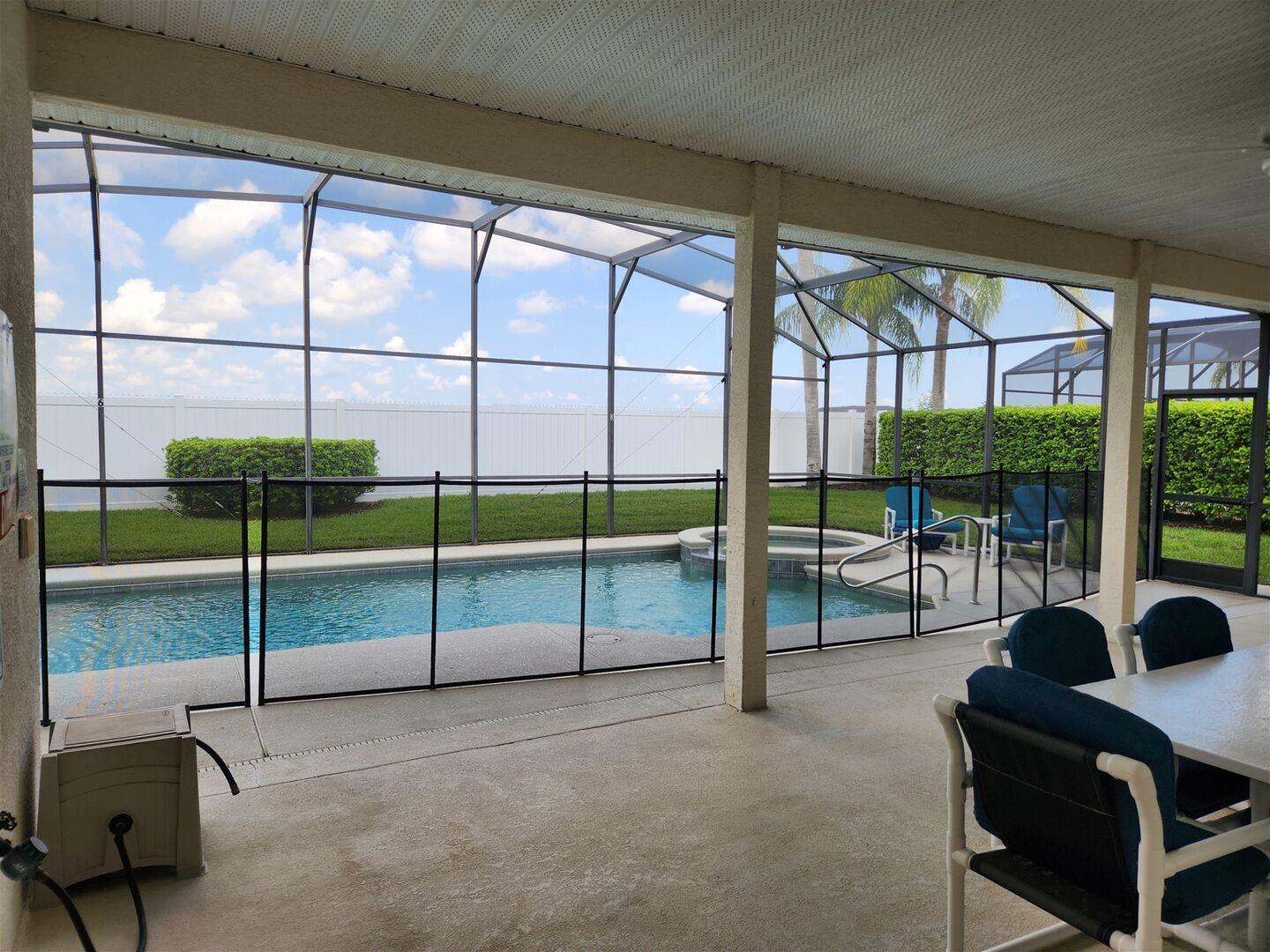Screened heated pool and spa seen from the covered lanai